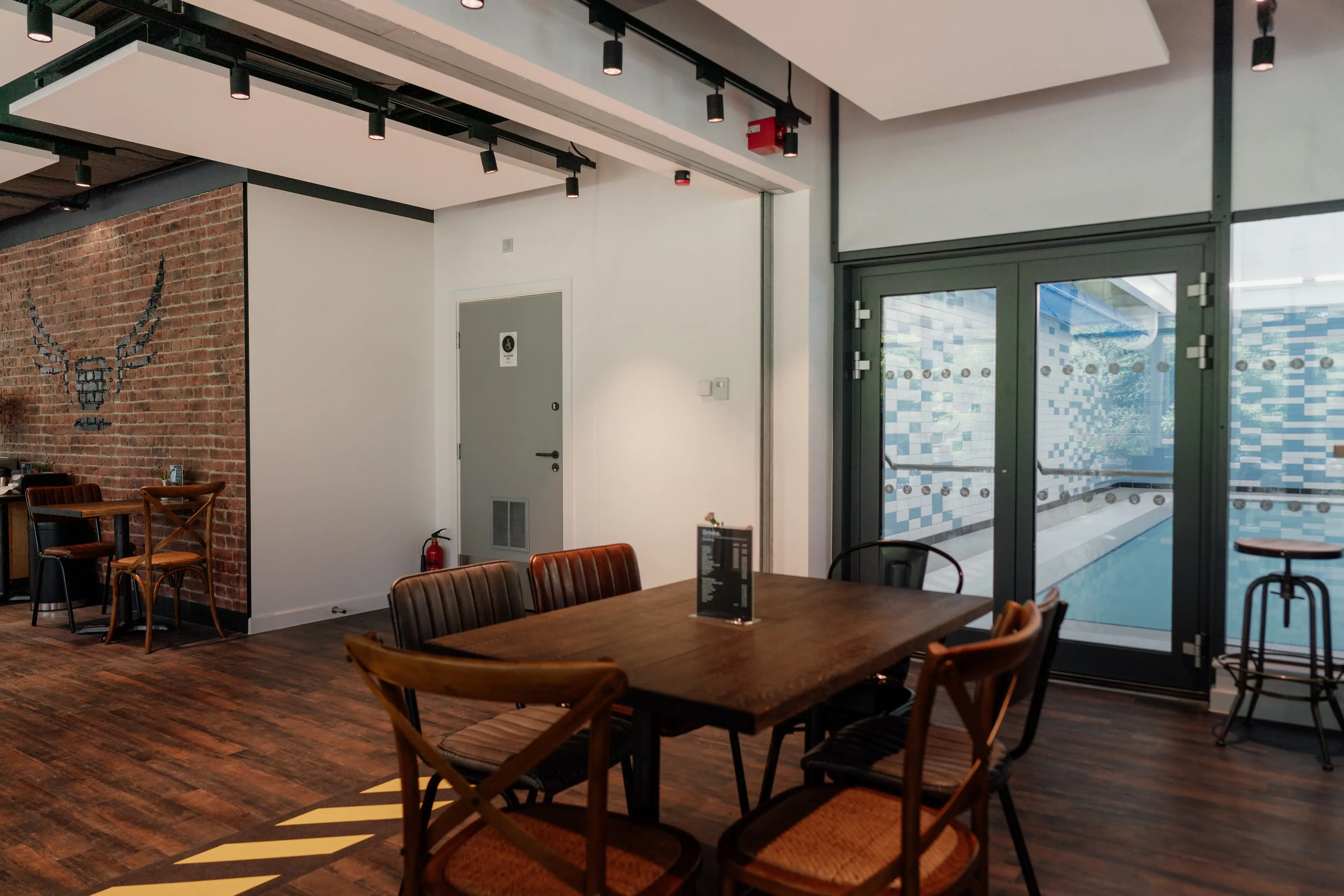 Cafe with tables and chair, with view of swimming pool