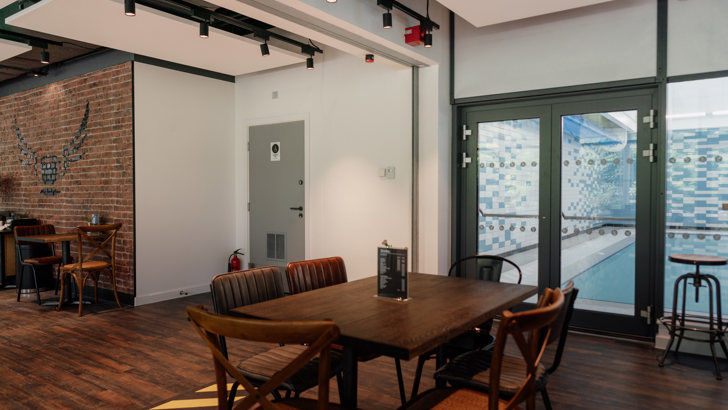 Cafe with tables and chair, with view of swimming pool