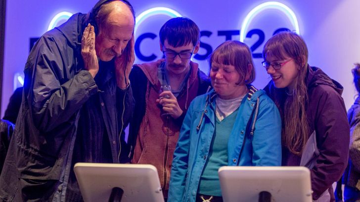 A family watching the digital exhibition on a tablet at the Forecast22 launch. 