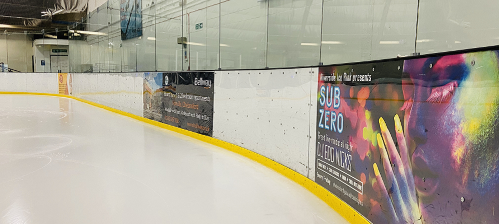 Adverts around the edge of the ice rink, with yellow strip marking the edge