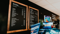 Black menu boards showing a selection of drinks and food options preview