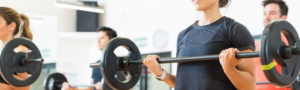 People lifting weighted bar in exercise class