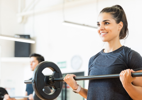 People lifting weighted bar in exercise class
