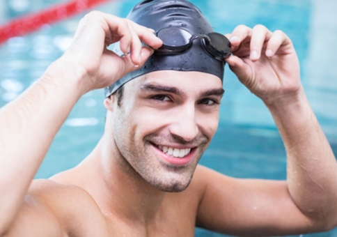 Smiling man in swimming cap with goggles