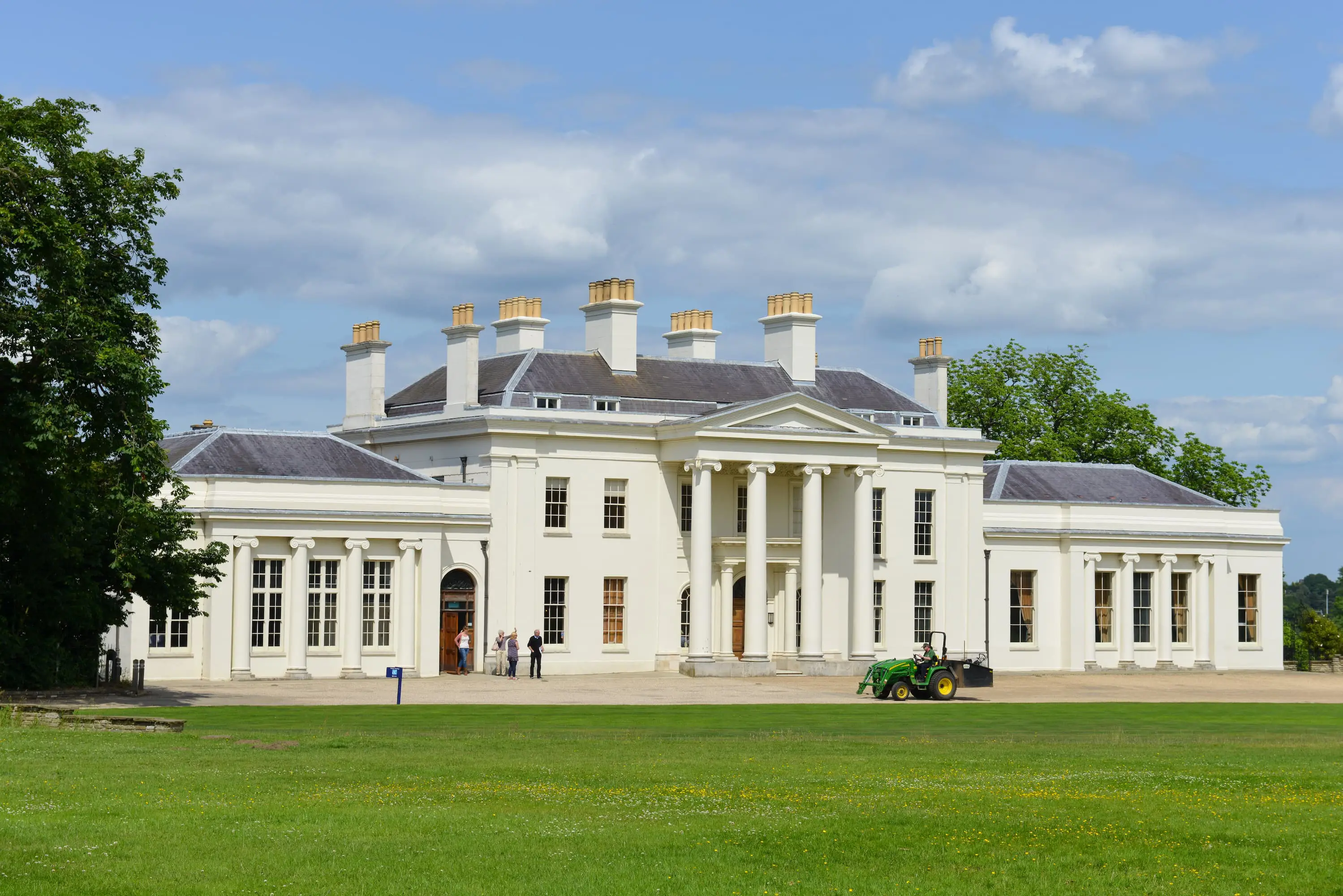 Front of Hylands House, a Grade II* neo-classical white villa with a portico entrance featuring four columns