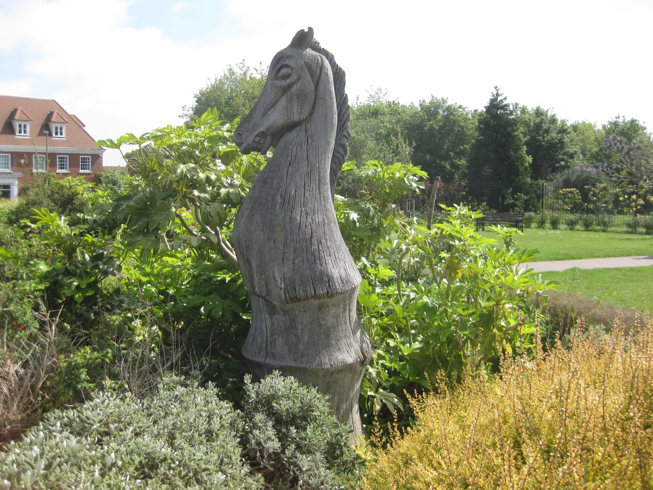 Large wooden sculpture of a knight chess piece in a public park