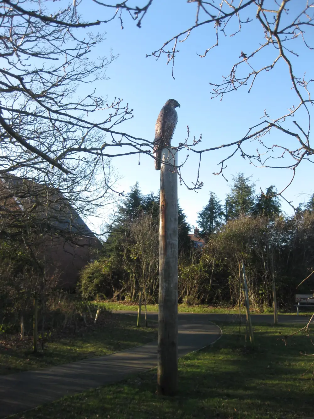 Tall timber post with sculpture of buzzard perched on top