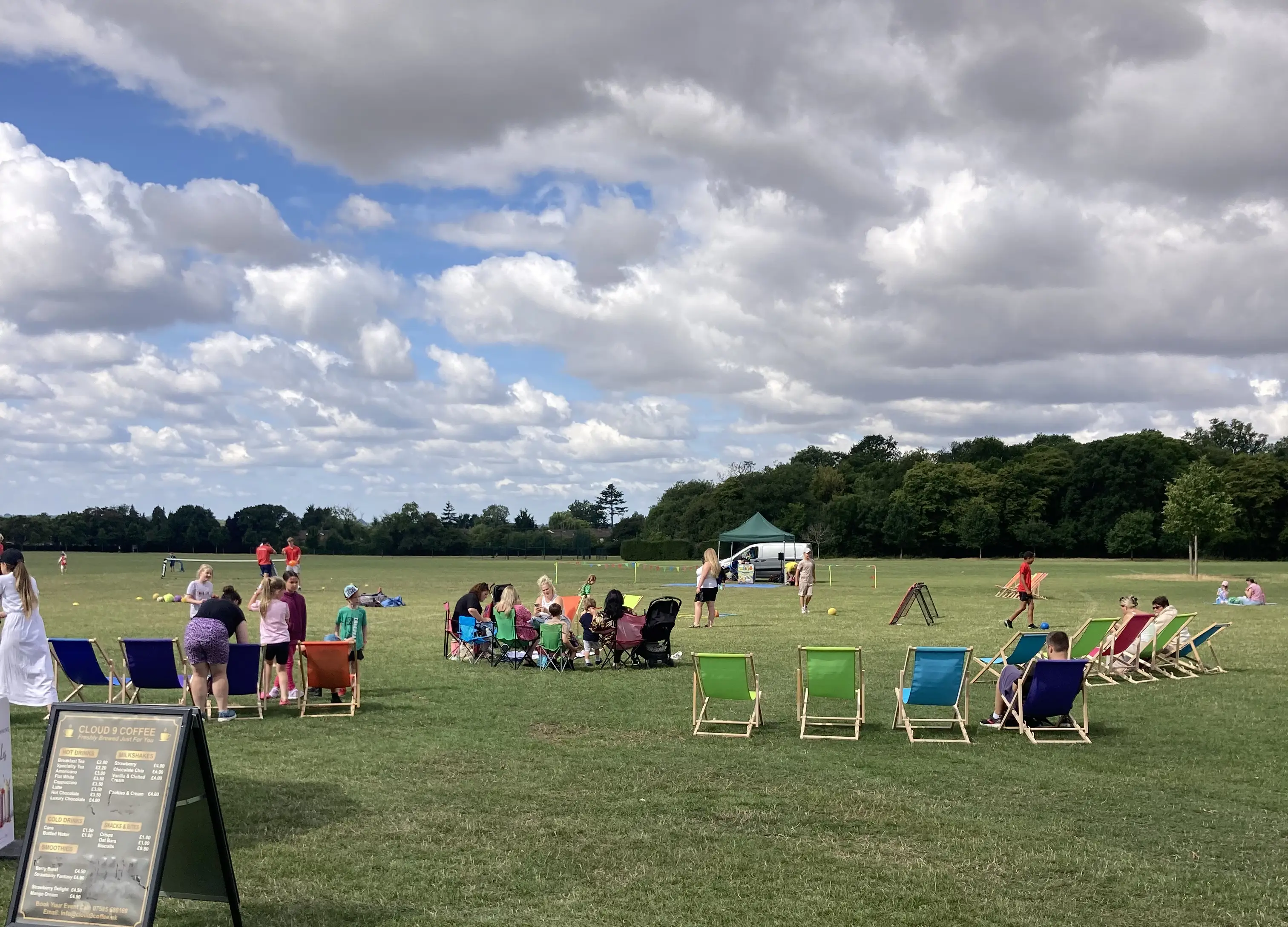 Large open field with people relaxing in brightly coloured deckchairs