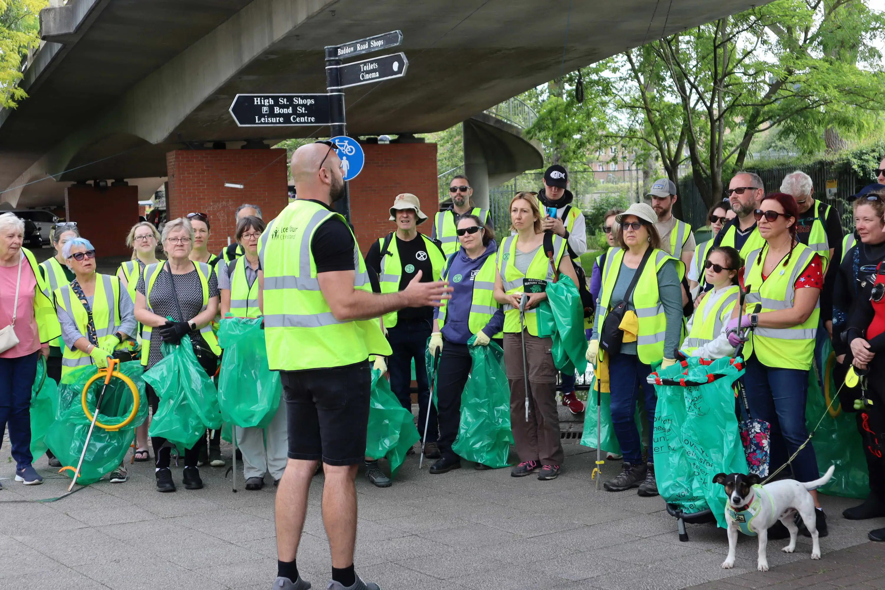 A group of people in high visibility jackets holding litter pickers
