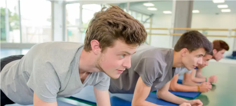 Older teenage boys holding the plank position in an exercise studio