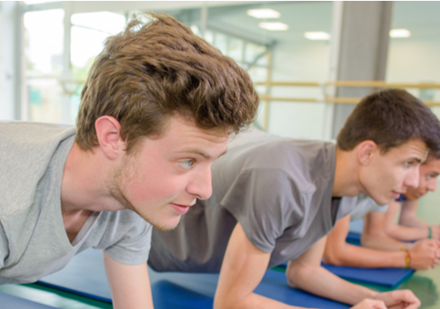 Older teenage boys holding the plank position in an exercise studio