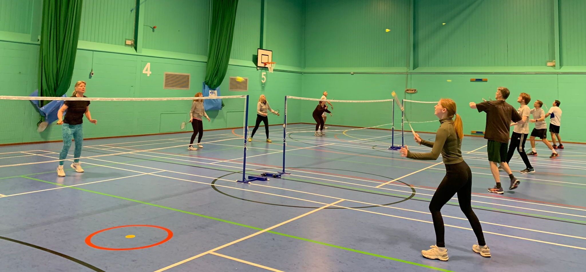 Group of people playing badminton in sports hall