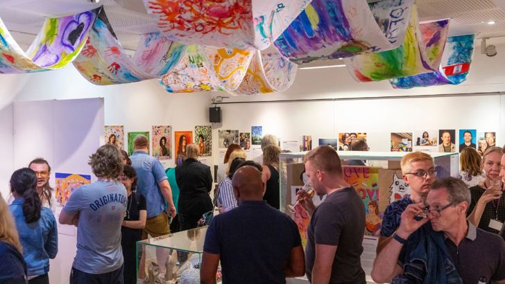 A crowd of visitors looking at displays at the Behind the Rainbow exhibition launch. 