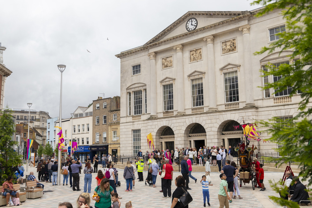 People mingling around in large public open space at top of Chelmsford High Street, outside Shire Hall