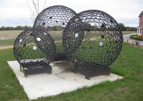 Three large metal spheres made of smaller circles