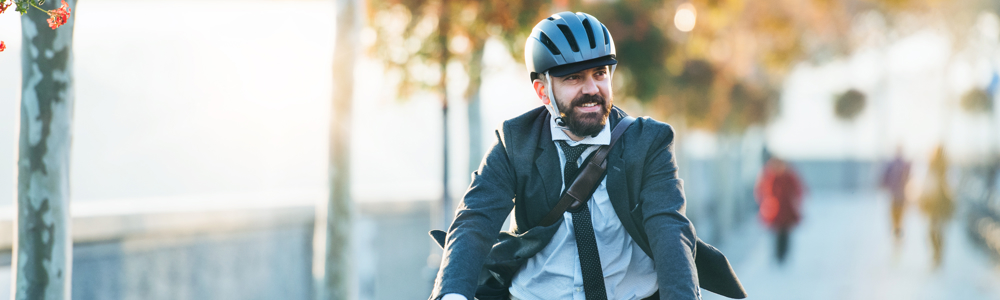 Man in suit riding bike in urban area