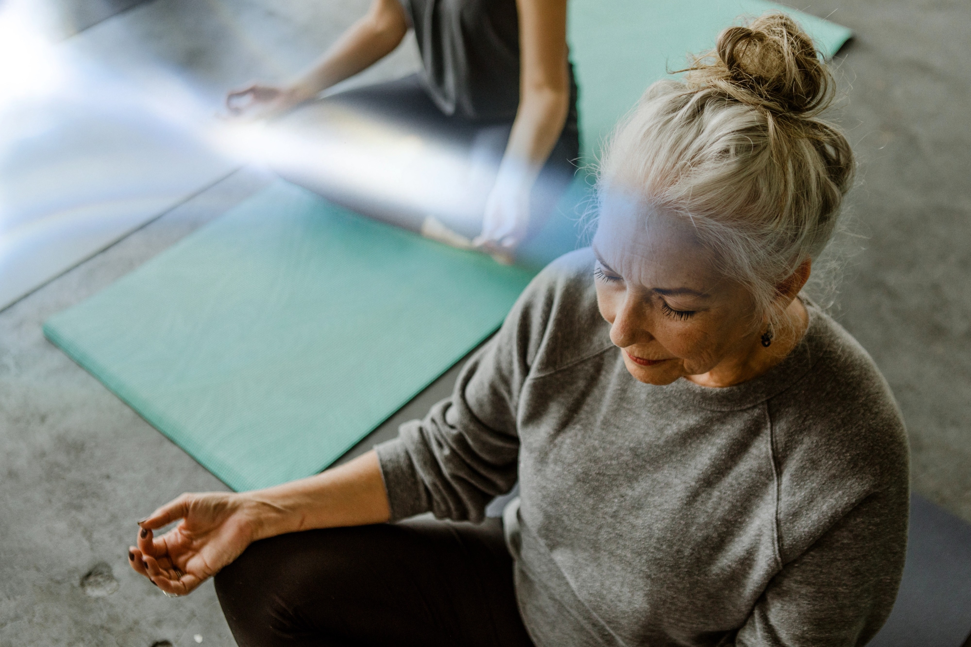 Woman sitting cross-legged on the floor with eyes closed