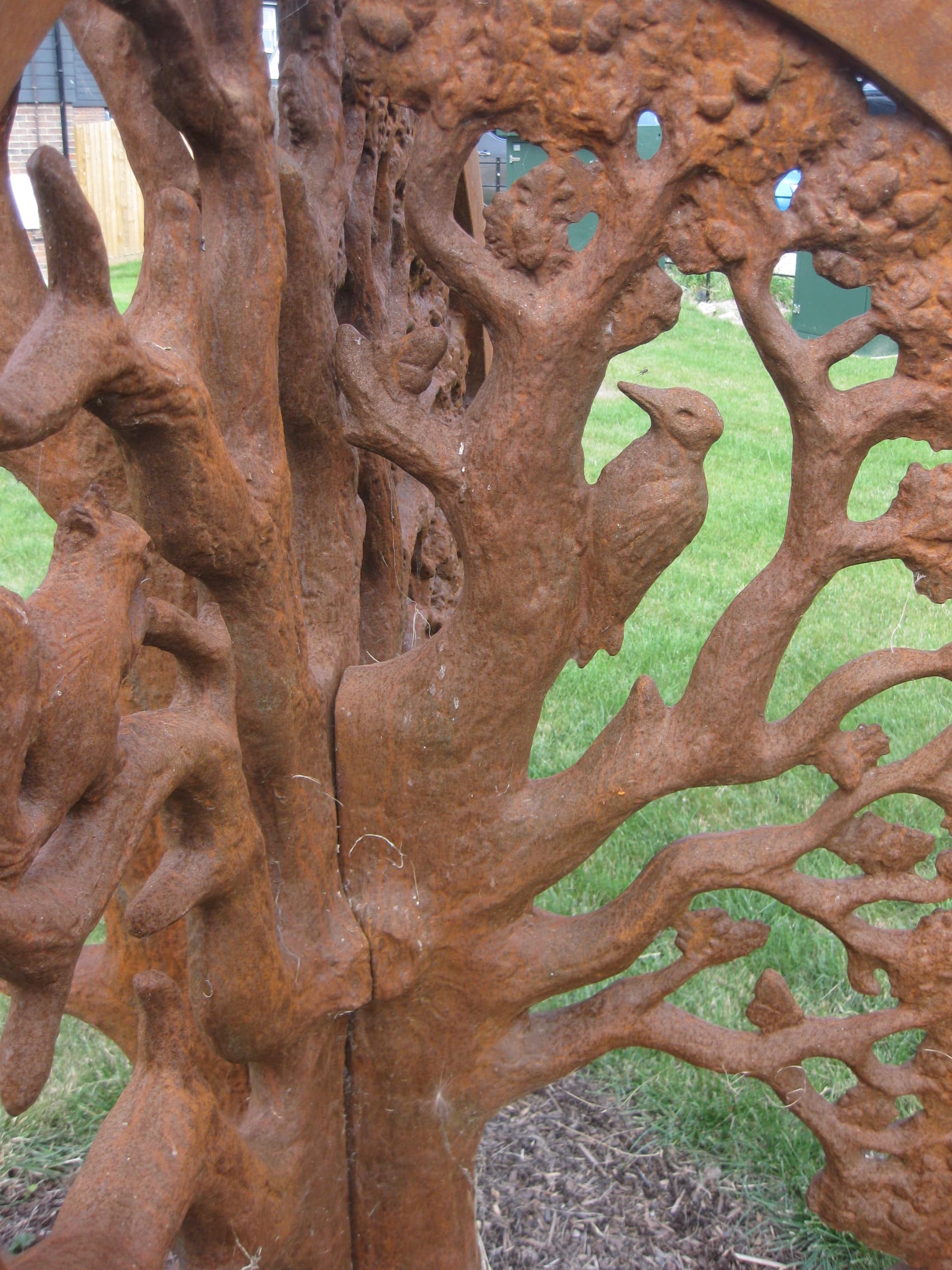 Spherical sculpture made from a metal depicting oak tree
