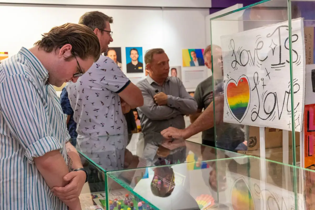 A person looking into a display cabinet at the Behind the Rainbow exhibition launch.