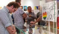 A person looking into a display cabinet at the Behind the Rainbow exhibition launch. preview