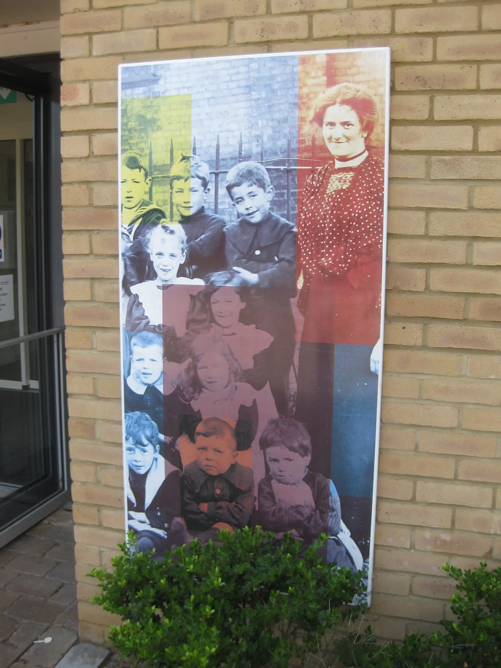 Vitreous enamel panel featuring photograph of nine children and a woman from Victorian or Edwardian era