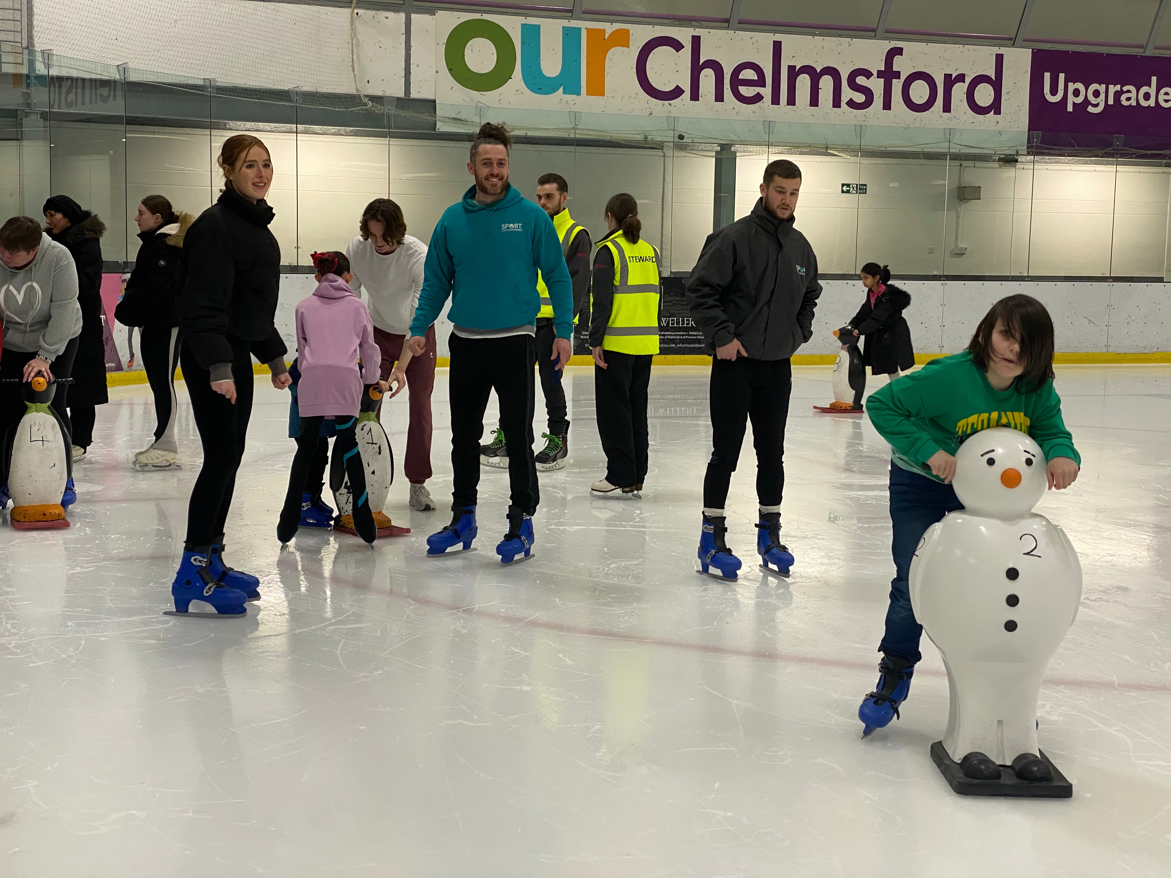 Coaches watching a child learn to ice skate