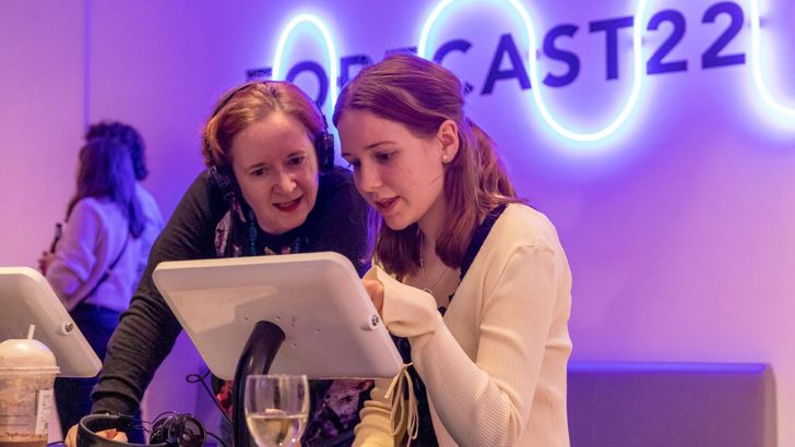 Two people looking at a tablet at the Forecast22 exhibition launch. 