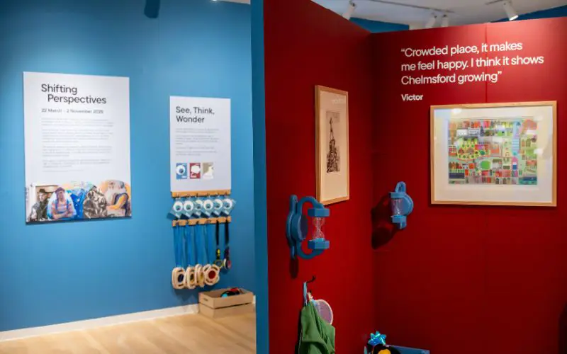 The Shifting Perspectives exhibition with bright blue and red walls and artwork on display.