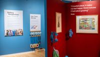 The Shifting Perspectives exhibition with bright blue and red walls and artwork on display.  preview