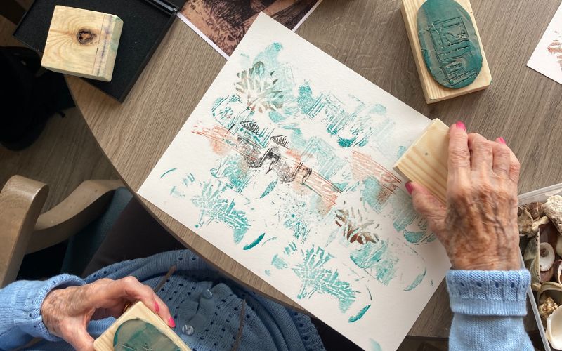 A woman creating artwork with rubber stamps. 