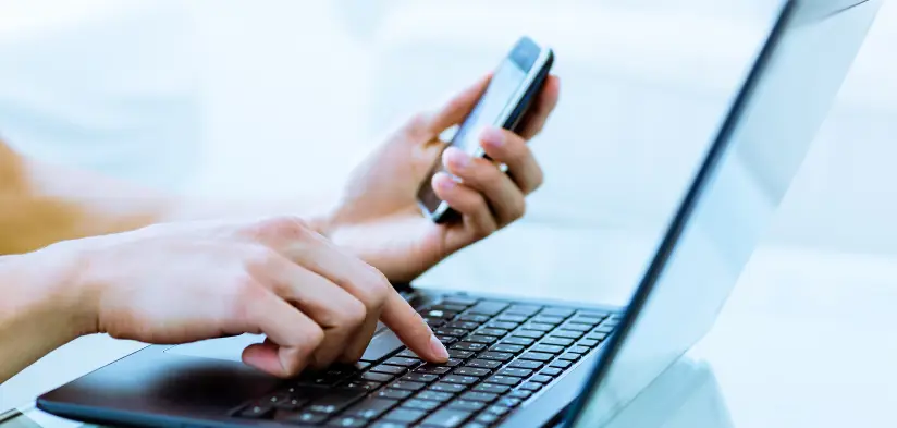 Person using laptop and phone