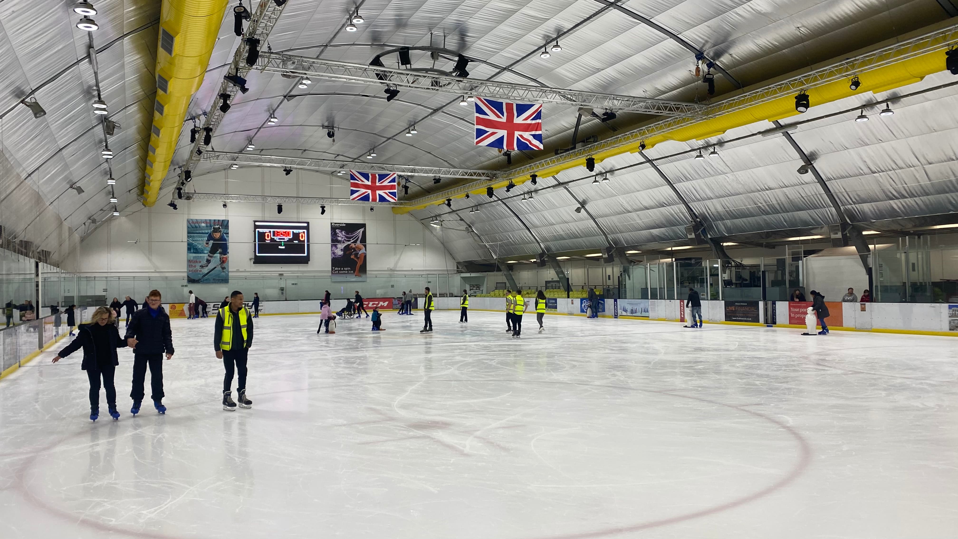 Group of people ice skating on an indoor ice rink