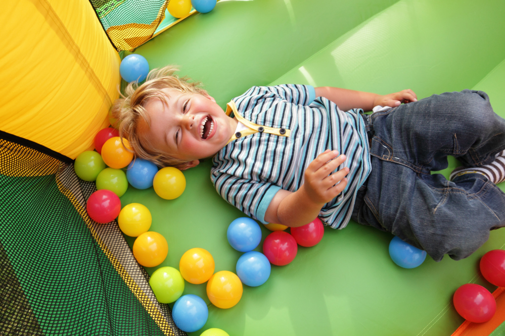 Laughing boy in soft play ball pit