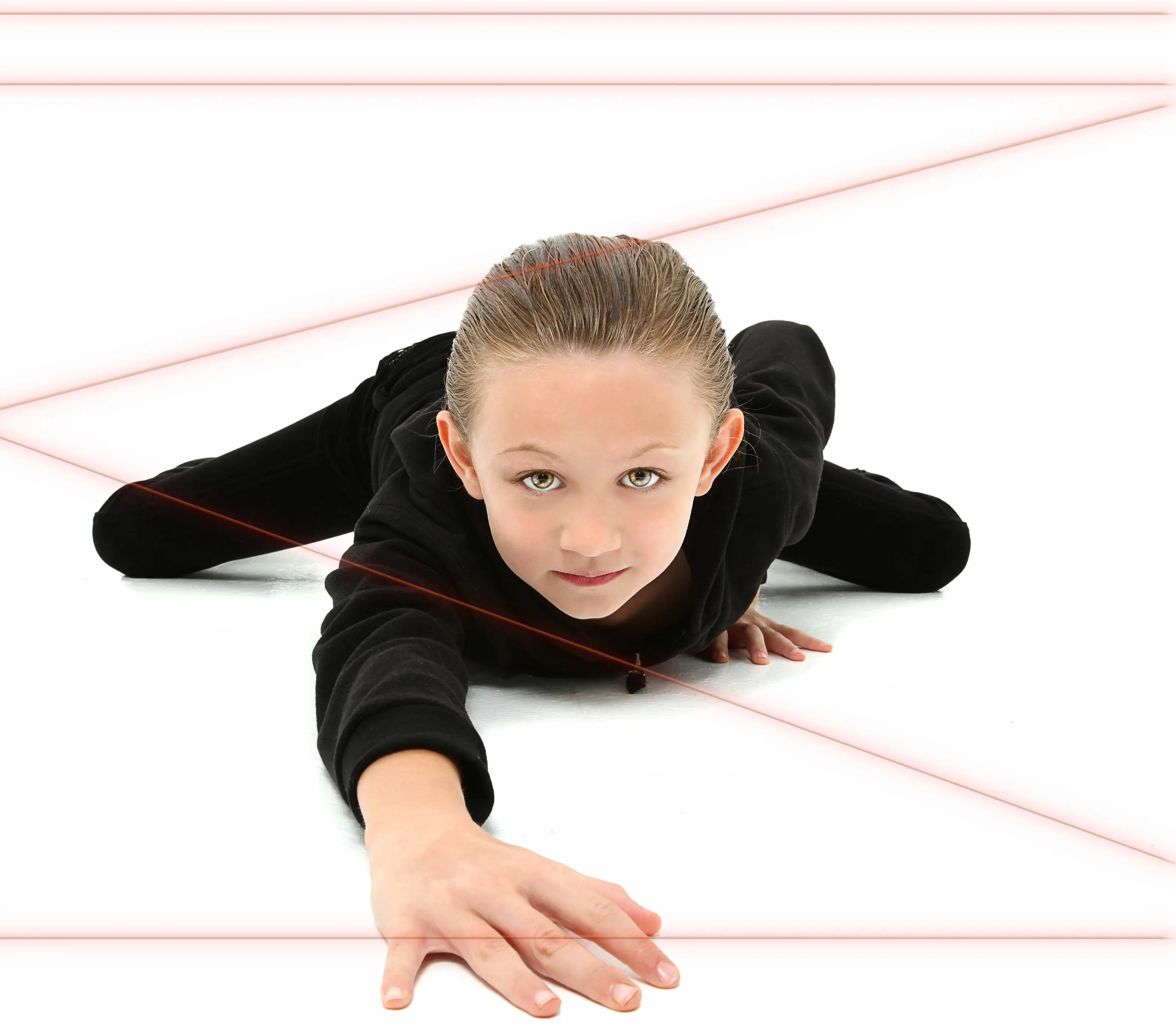 Young girl in spy costume dodging red lasers