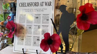 Chelmsford at War book on display near red poppies. 