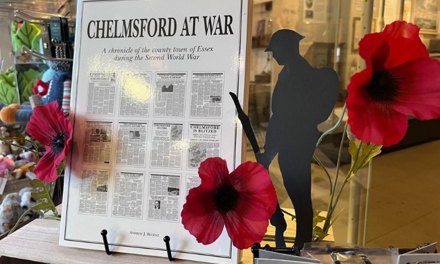 Chelmsford at War book on display near red poppies. 