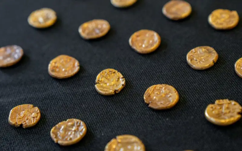A close up of gold coins laid out on a table.