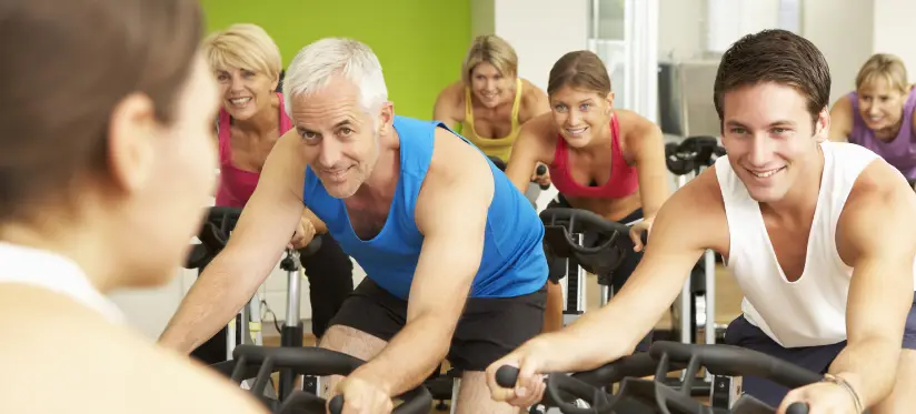 A group of adults participate in a cycling exercise class