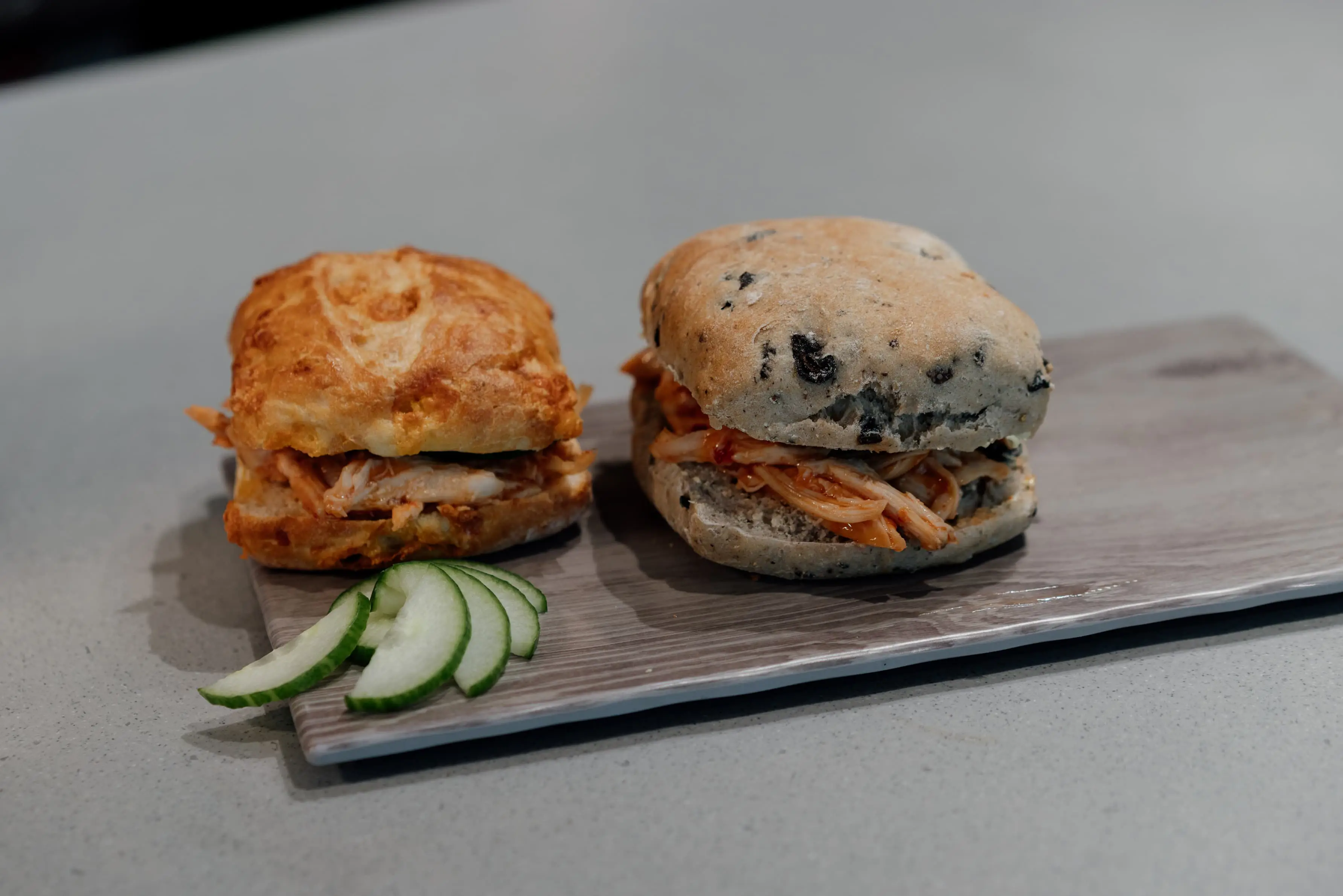 Two sandwiches with cucumber garnish