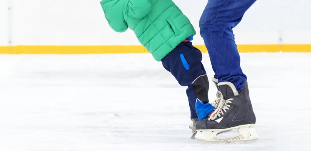 Small child being helped to balance on the adult by an adult