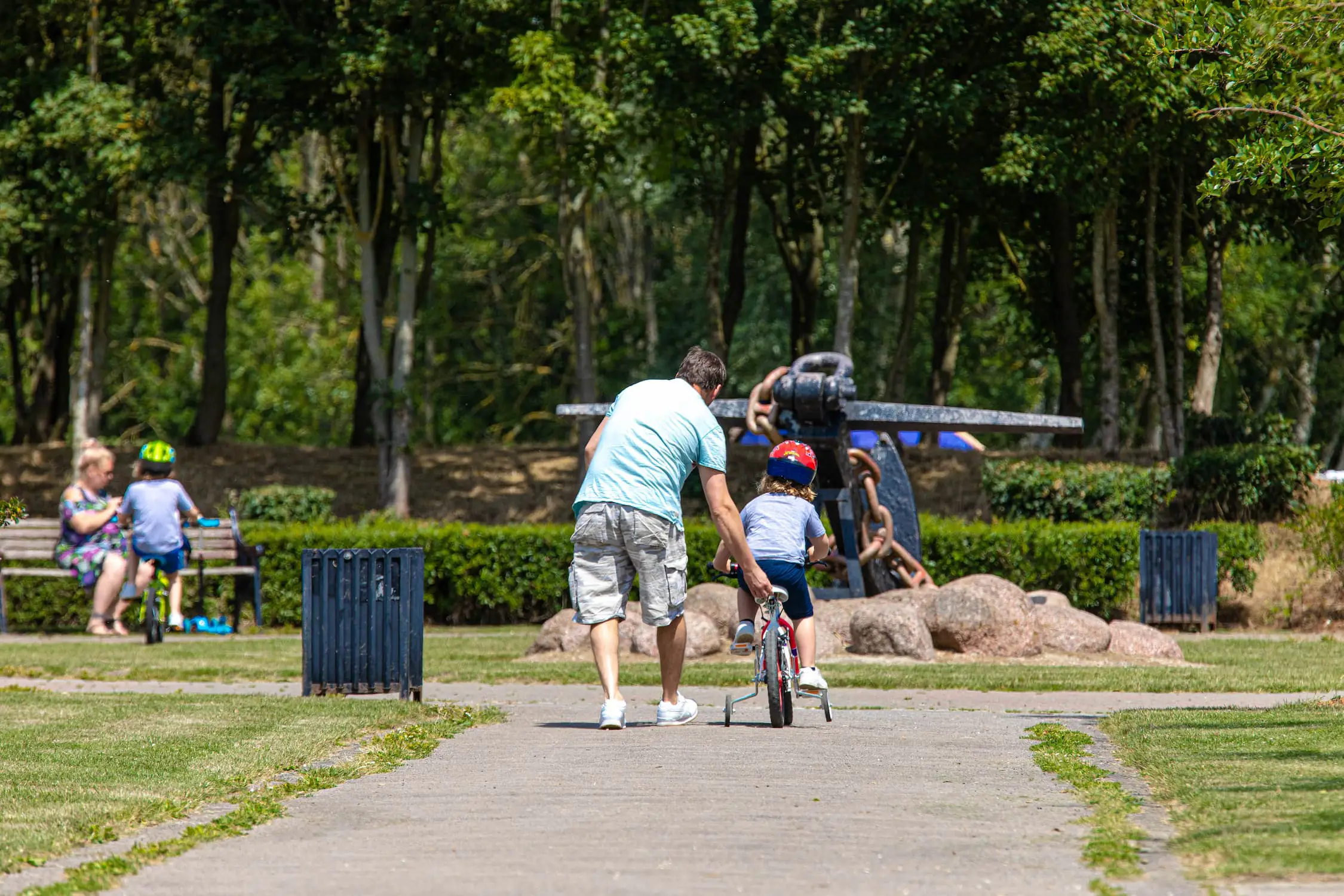 Father helping his son learn to ride a bike
