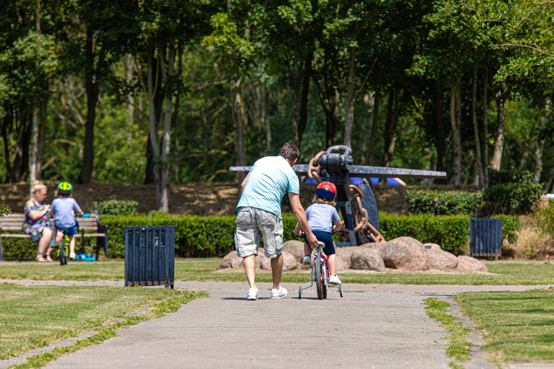 Father helping his son learn to ride a bike preview