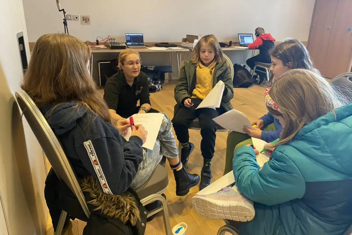 A group of kids at Radio Club sit in a circle working on their scripts. 