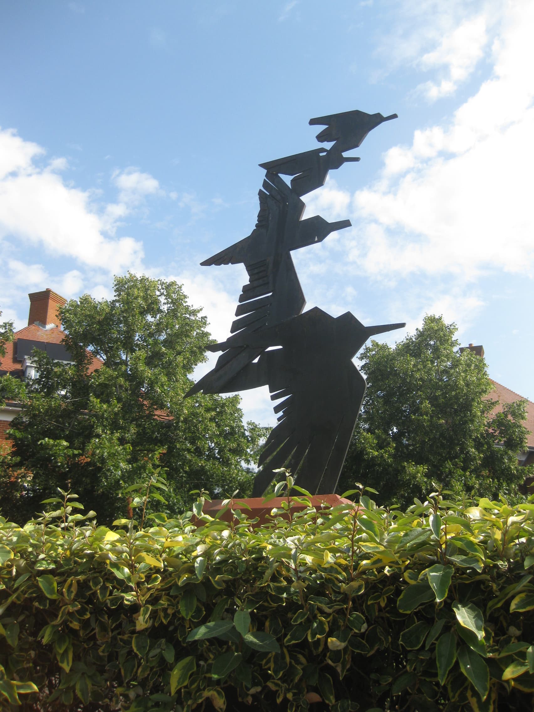 Sculpture depicting four black steel birds in flight, of decreasing sizes