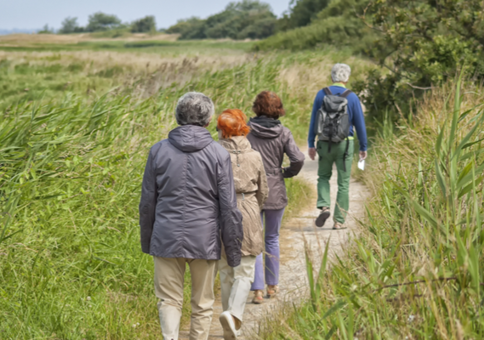 Man leading walkers along riverside walk