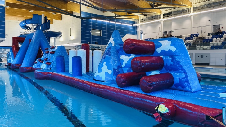 Large blue and red inflatable assault course floating on top of water at Riverside swimming pool