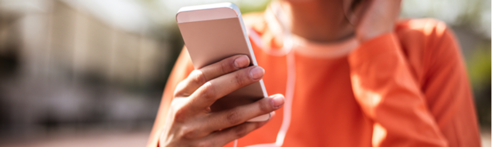 Woman wearing orange top using smart phone