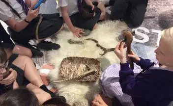 Children playing with stone age historic items