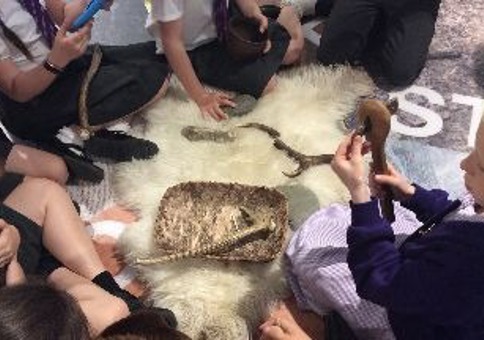 Children playing with stone age historic items