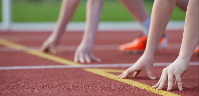 Kids lining up at the start line on an athletics track